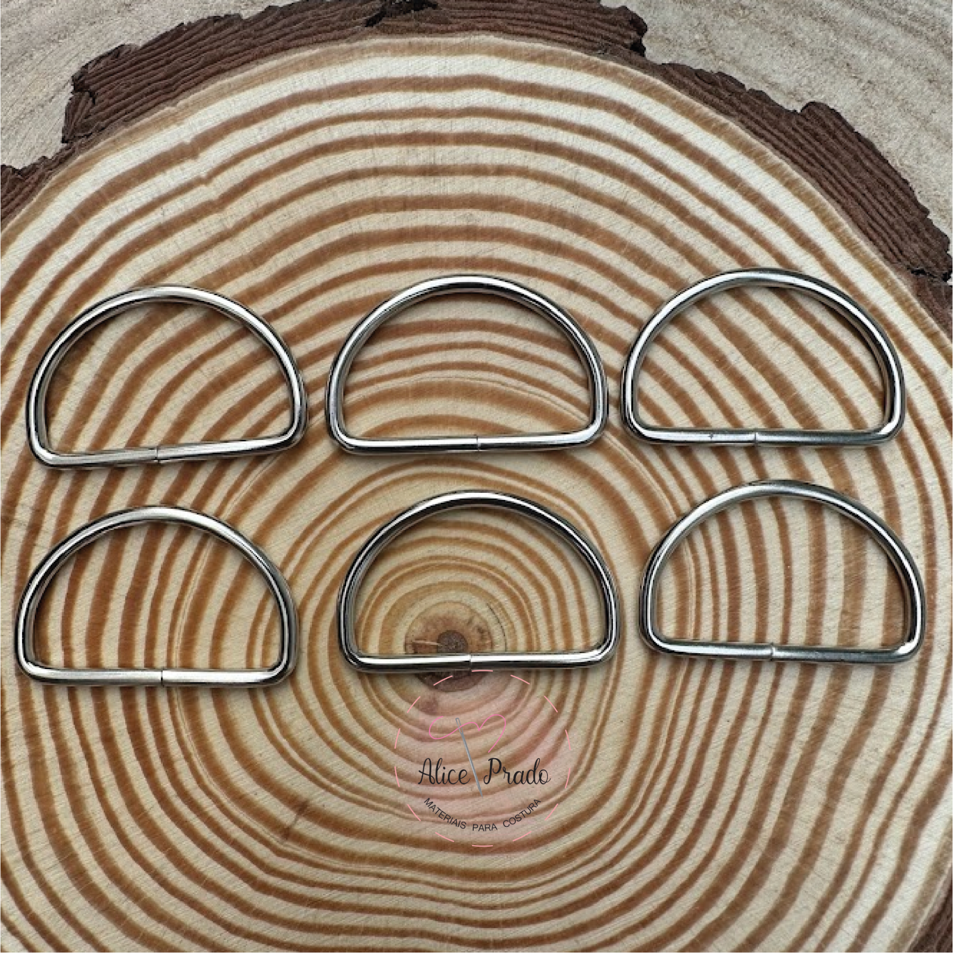 Seis argolas metálicas em forma de D sobre madeira com anéis concêntricos