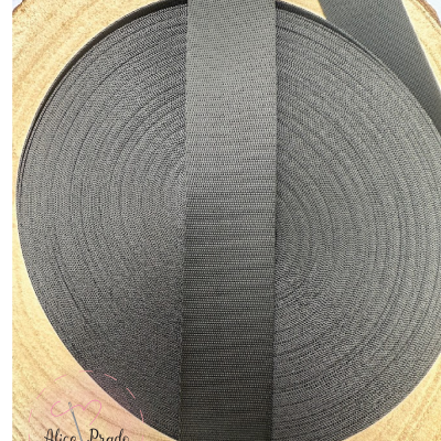 Rolo de fita preta larga sobre madeira clara com selo Alice Prado