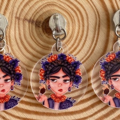 Três pendentes transparentes com imagem artística de mulher com flores no cabelo sobre madeira