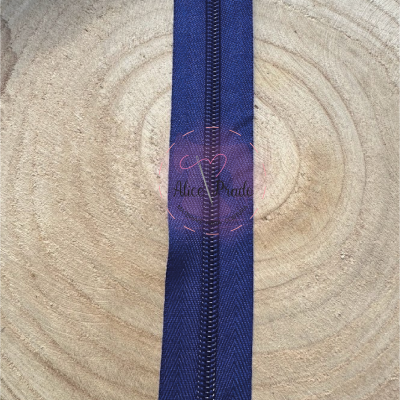 Fecho éclair azul escuro sobre madeira clara com padrão espinha de peixe