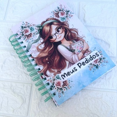 Caderno espiral com capa ilustrada de rapariga e texto 'Meus Pedidos'