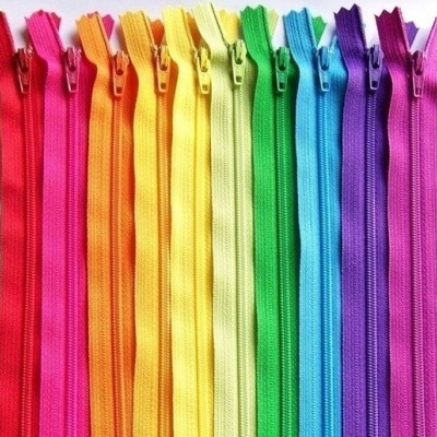 Doze fechos éclair coloridos em sequência de cores do arco-íris