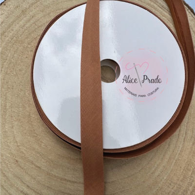 Rolo de fita marrom com etiqueta Alice Prado sobre base de madeira