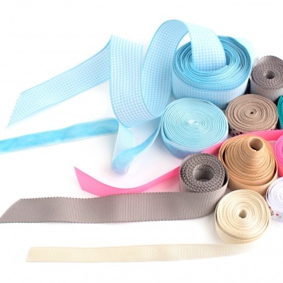 Rolos de fitas coloridas em diferentes tons sobre fundo branco