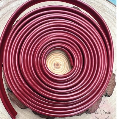 Mola de metal vermelha em espiral sobre tábua de madeira clara