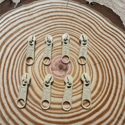 Oito cursores de zíper bege em tronco de madeira com anéis de crescimento