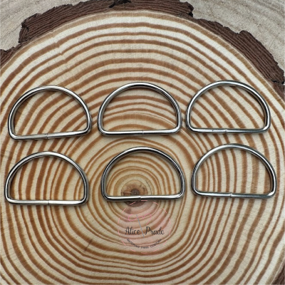 Seis argolas metálicas em forma de D sobre madeira com anéis concêntricos