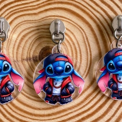 Três porta-chaves do Stitch com roupa vermelha e preta sobre fundo de madeira circular