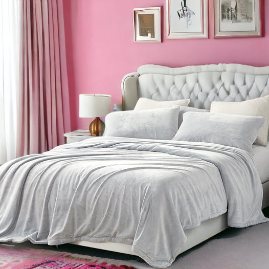 Conjunto de cama cinzento claro aveludado com cabeceira estofada, candeeiro dourado e parede rosa