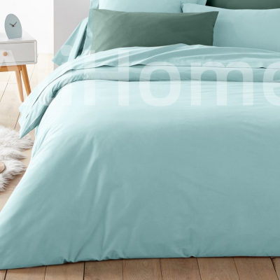 Conjunto de roupa de cama azul clara com almofadas azuis, cama numa sala com mesa de cabeceira e piso em madeira