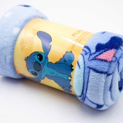 Manta polar azul com ilustração de Stitch e etiqueta amarela