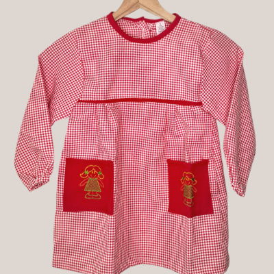 Vestido infantil xadrez vermelho e branco com bolsos vermelhos bordados.