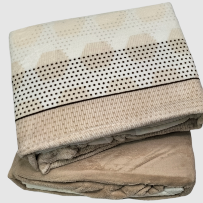 Manta dobrada em cores bege, branco e castanho com padrão geométrico