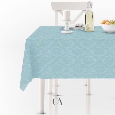 Toalha de mesa azul claro com padrão floral sobre mesa branca e acessórios
