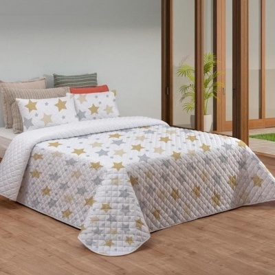 Cama casal com edredão e almofadas com estrelas douradas e cinzentas