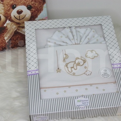 Conjunto de roupinha de bebé branca com bordados de ursinho em caixa branca com padrão cinzento