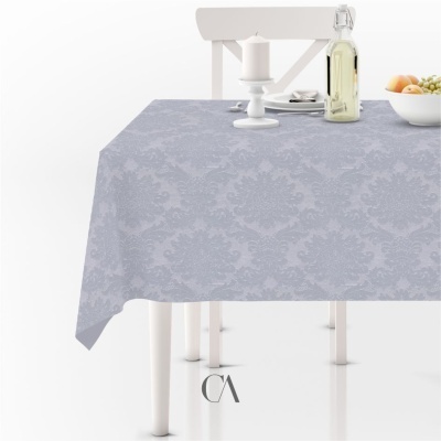 Toalha de mesa cinzenta com padrão damasco sobre mesa branca com cadeira, prato, vela, garrafa e tigela de fruta