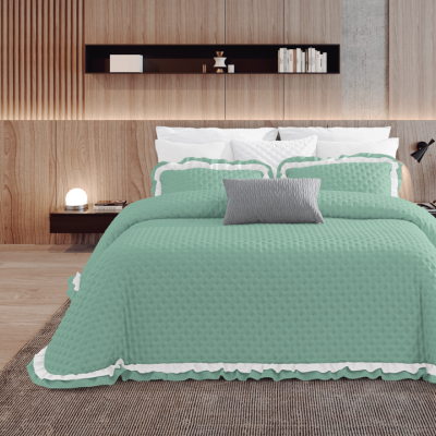 Cama de casal com edredão verde água matelassê e bordas brancas, cabeceira de madeira clara, mesas de cabeceira pretas e decoração minimalista