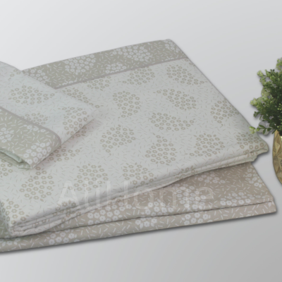 Conjunto de roupa de cama bege com padrão floral e planta em vaso dourado