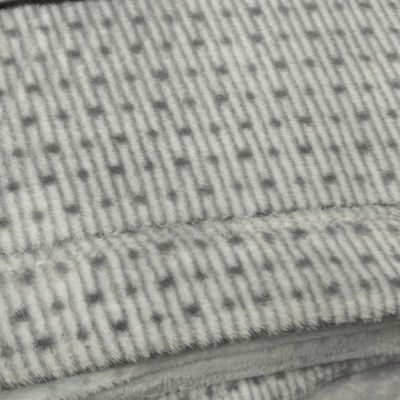 Tecido cinza claro com padrão de pontos e textura acolchoada