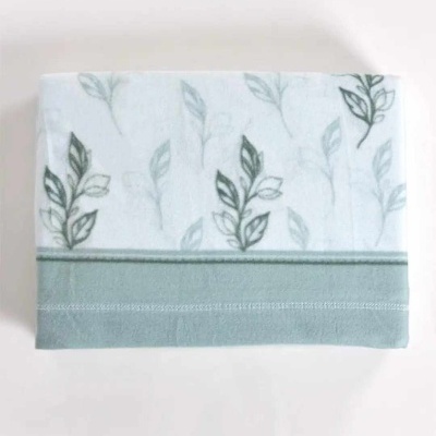 Toalha branca com padrão de folhas verdes e faixa verde