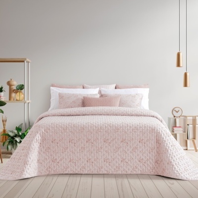 Cama de casal com colcha rosa clara estampada e almofadas em quarto moderno minimalista