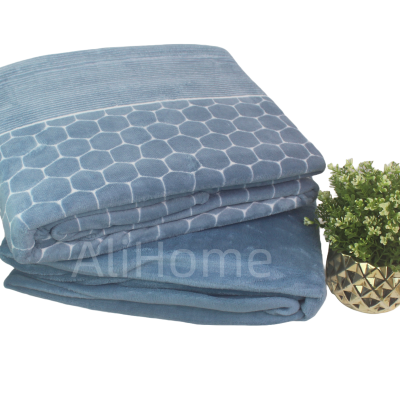 Manta azul com padrão hexagonal branco e vaso dourado com planta