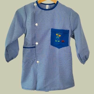 Bata infantil azul e branca xadrez com bolso azul e bordado colorido