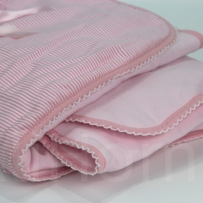 Têxtil rosa dobrado com riscas finas e bordas decorativas
