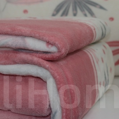 Toalhas rosa e branco dobradas com padrão suave ao lado de vaso dourado com plantas