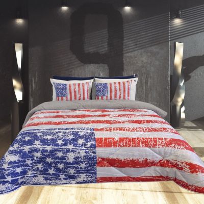 Cama com colcha e fronhas padrão bandeira americana ao centro de quarto moderno