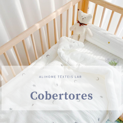 Berço de madeira clara com roupa de cama branca e urso de pelúcia