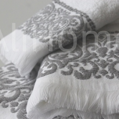 Toalhas de banho brancas com padrão cinzento e franjas na extremidade