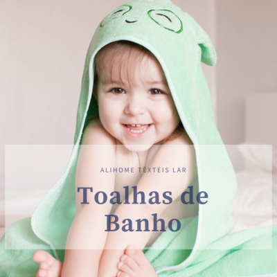Criança em toalha de banho verde com capuz sorrindo