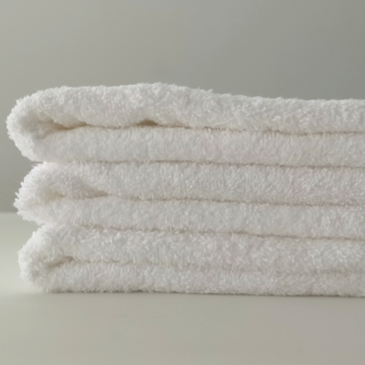 Pilhas de toalhas brancas felpudas sobre uma superfície branca