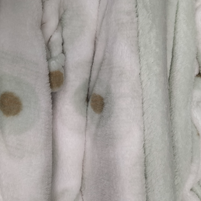 Tecido de pelúcia branco com pontos castanhos e textura felpuda
