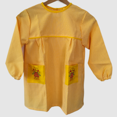 Avental infantil amarelo xadrez com bolsos e desenhos de bonecas