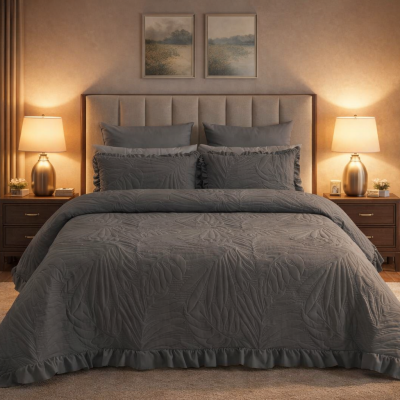 Conjunto de roupa de cama cinzenta com edredão e almofadas com padrão acolchoado, mesa de cabeceira, candeeiro e decoração de quarto