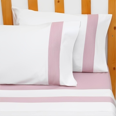 Jogo de roupa de cama branca com faixas rosas em cama com cabeceira de madeira clara
