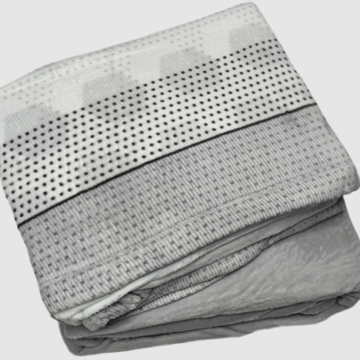 Cobertor dobrado com padrão cinza, branco e preto