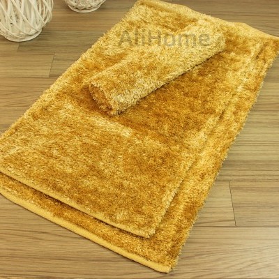 Tapete mostarda de pelo comprido sobre chão de madeira clara com decoração de bolas de fibras naturais brancas