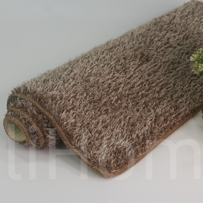 tapete felpudo castanho claro com vaso decorativo ao lado