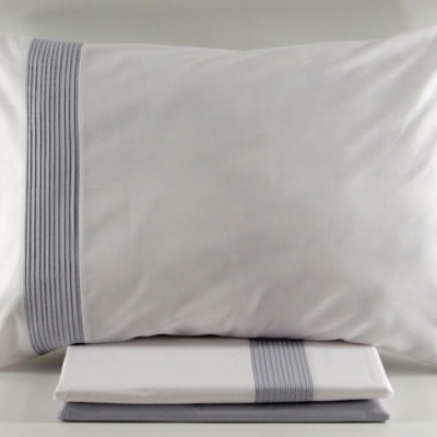 Almofada e lençol branco com faixa cinza de pregas verticais