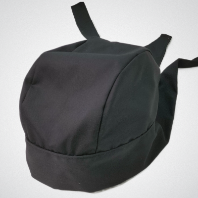 Mochila preta simples com alças ajustáveis sobre fundo cinzento