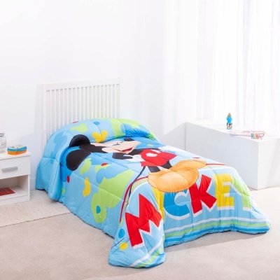 Cobertor azul claro com ilustração do Mickey Mouse e letras MICKEY numa cama branca