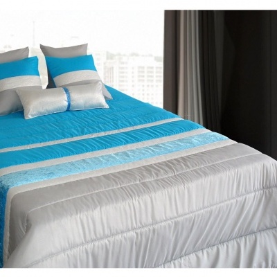 Colcha de cama azul, cinzenta e branca com almofadas correspondentes