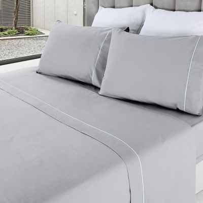 Cama com jogo de cama cinzento e branca com linhas brancas