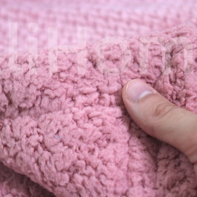 Tecido rosa felpudo com textura macia sendo segurado por uma mão