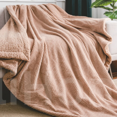 Manta bege com padrão quadrado sobre sofá cinza claro