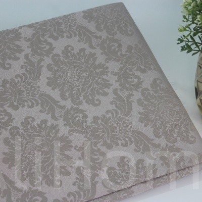 Tecido estampado floral em bege com planta ao lado em vaso metálico